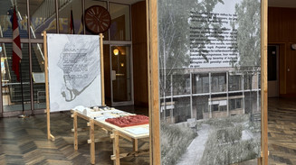 Udstilling med arkitekturmodeller og plancher i en rådhushal.
