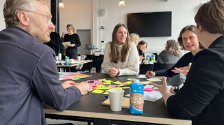 Dialog omkring et bord til modulet design, ledelse og relationer