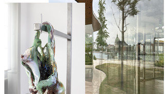 Abstrakt glasskulptur hænger på metalstativ foran en buet glasfacade med trærefleksion og udsigt mod byens kuppel.
