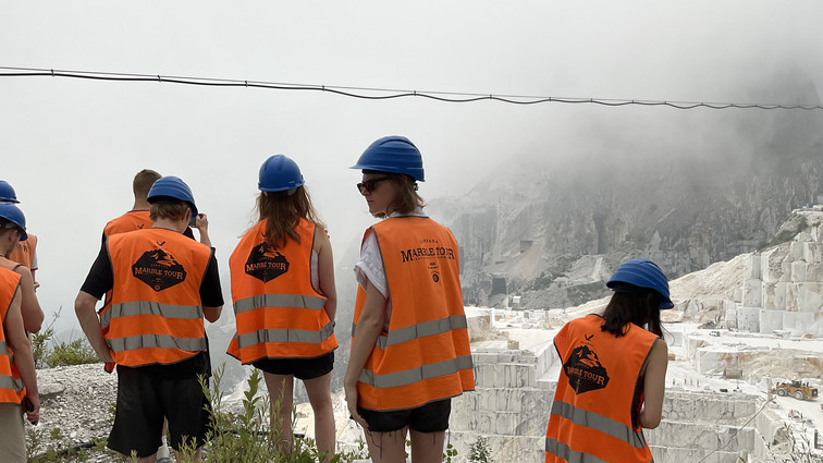 Studerende i orange veste og blå hjelme