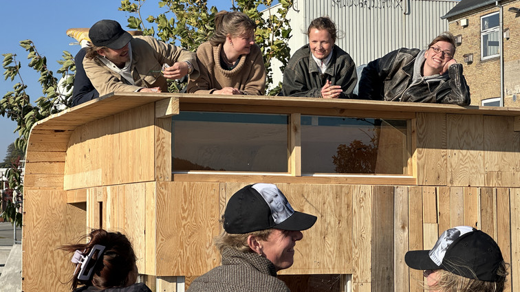 Unge mennesker arbejder på en pavillon i træ