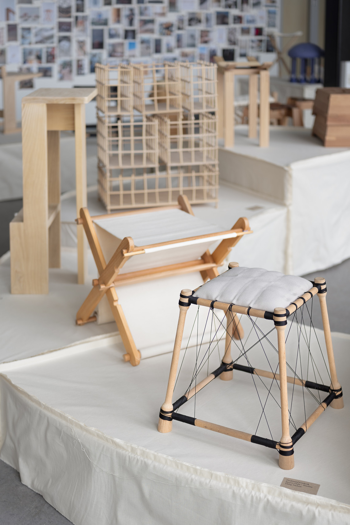 Wooden furniture prototypes and architectural model on display.