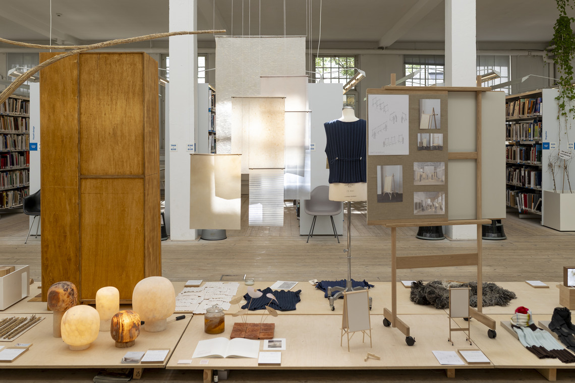 Library exhibition with hanging material samples, mannequin, and display boards