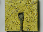 yellow square with grey lava glaze spilling from inside