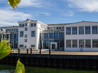White waterfront building with large windows.