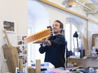 Person photographing a colorful circular design object in a studio.
