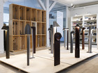 Display of outdoor light fixtures on platforms with shelving and books in the background