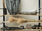 Shelves displaying handmade ceramic vessels, tools, and materials.