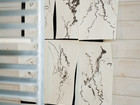 Abstract ink drawings pinned to a wall in a studio.