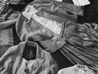 Assorted jackets, shirts and trousers arranged in an overlapping composition.