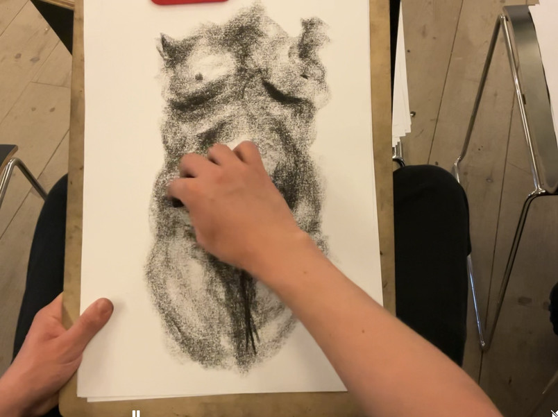Hånd tegner på skitse af torso