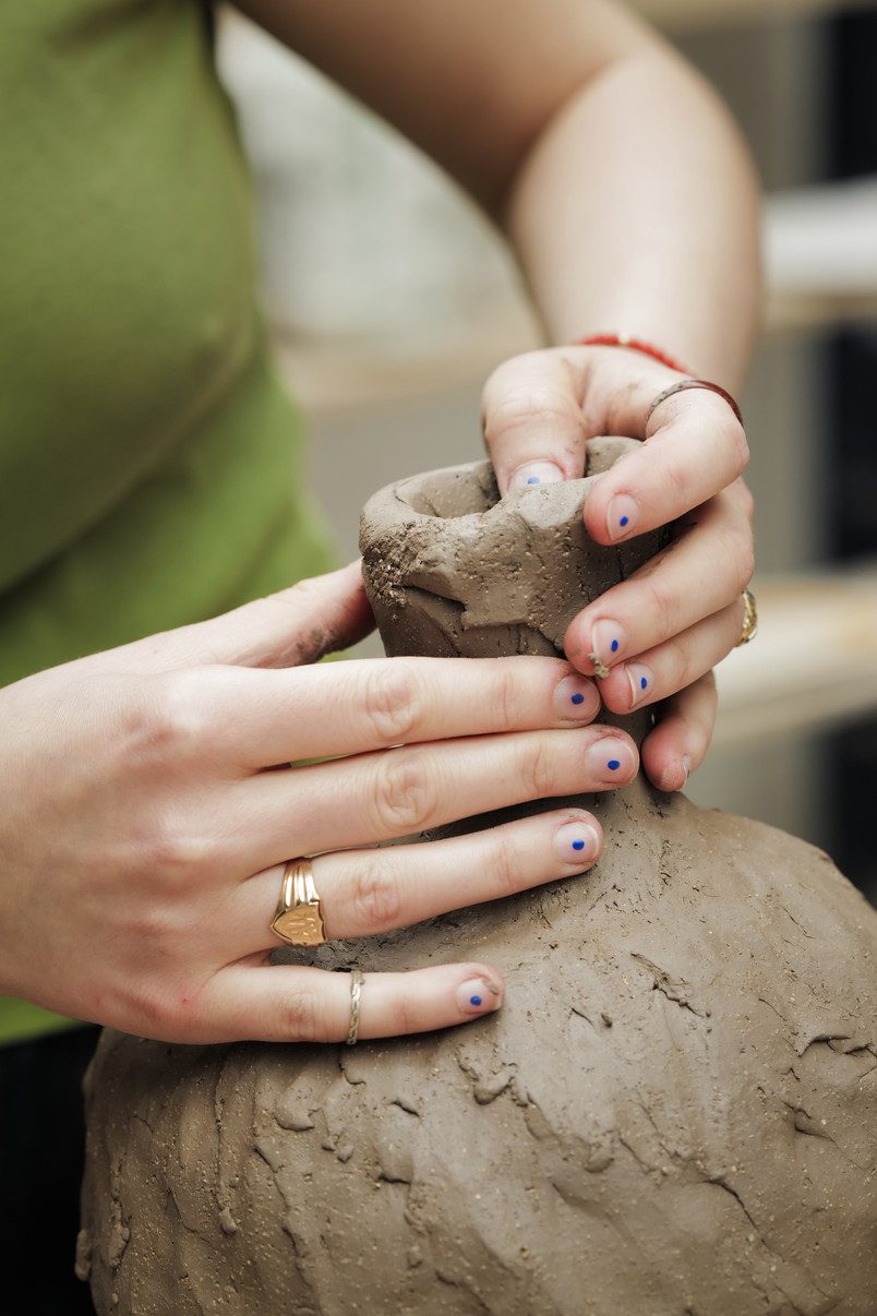 hands building on vase