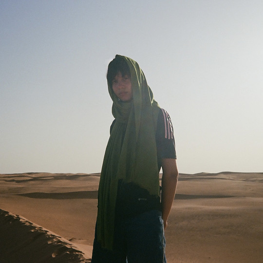 Suree out in the desert. Wearing a green scarf