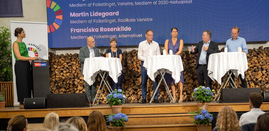 Seks paneldeltagere, heriblandt Lene Dammand Lund, Martin Lidegaard og Franciska Rosenkilde står på en scene og diskuterer bæredygtighed