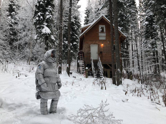Skikkelse i sneen, hus i baggrunden