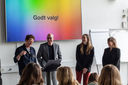 Fire personer foran en regnbuefarvet skærm med teksten 'Godt valg!'