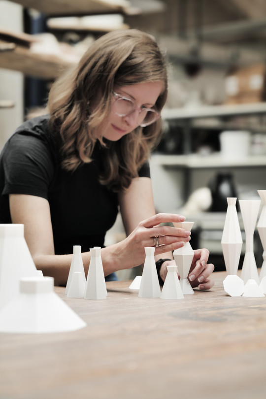 Woman stacking small pyramids on top of each other