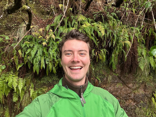 Smiling photo of Benjamin Fife with verdant ferns in the background.