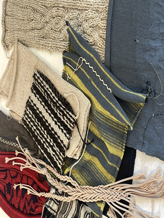 Collection of knitted textile samples in varied colors, patterns, and textures.