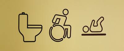 Piktogrammer af toilet, kørestolsbruger og baby på skifteplads