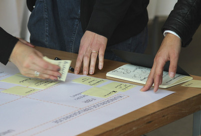 Design thinking Post-its og hænder på et bord med papir