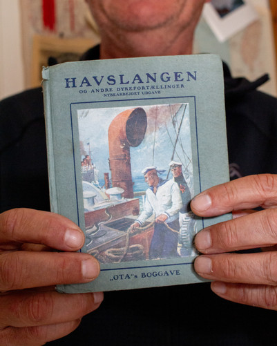Bog med titlen 'Havslangen' holdt op foran kameraet