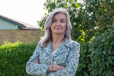 Charlie C Steenberg standing in front of a green hedge