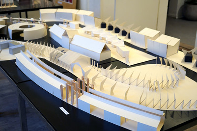 Arkitektonisk model med hvide bygningsformer på bord