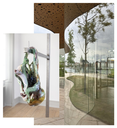 Abstrakt glasskulptur hænger på metalstativ foran en buet glasfacade med trærefleksion og udsigt mod byens kuppel.