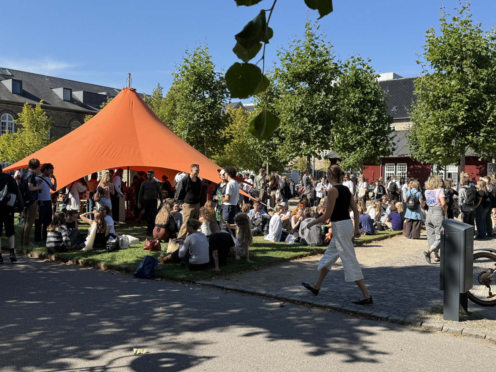 mange mennesker og orange telt på græsplæne