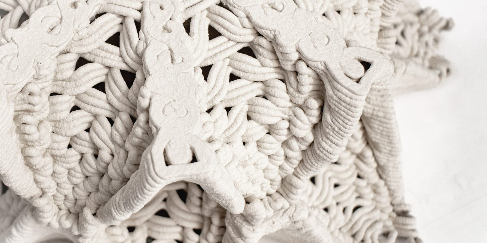Nærbillede af detaljeret, flettet 3D-printet keramikstruktur.
