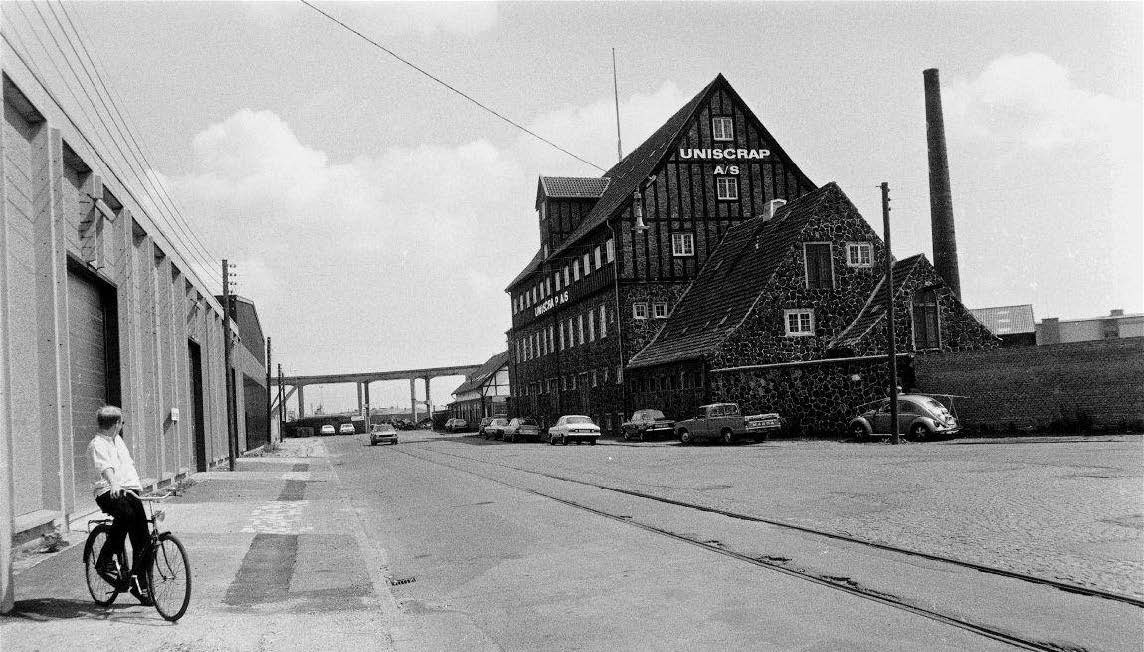 Old photograph of a street a building and a man on a bike