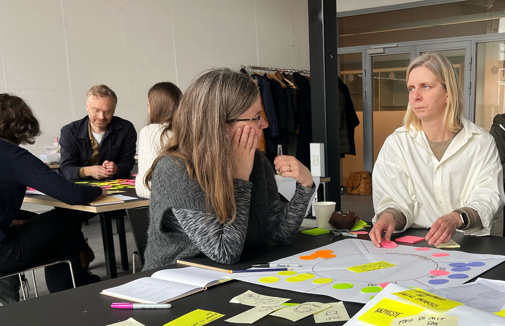 Deltagere rundt om et bord til Design, Strategi & Organisation