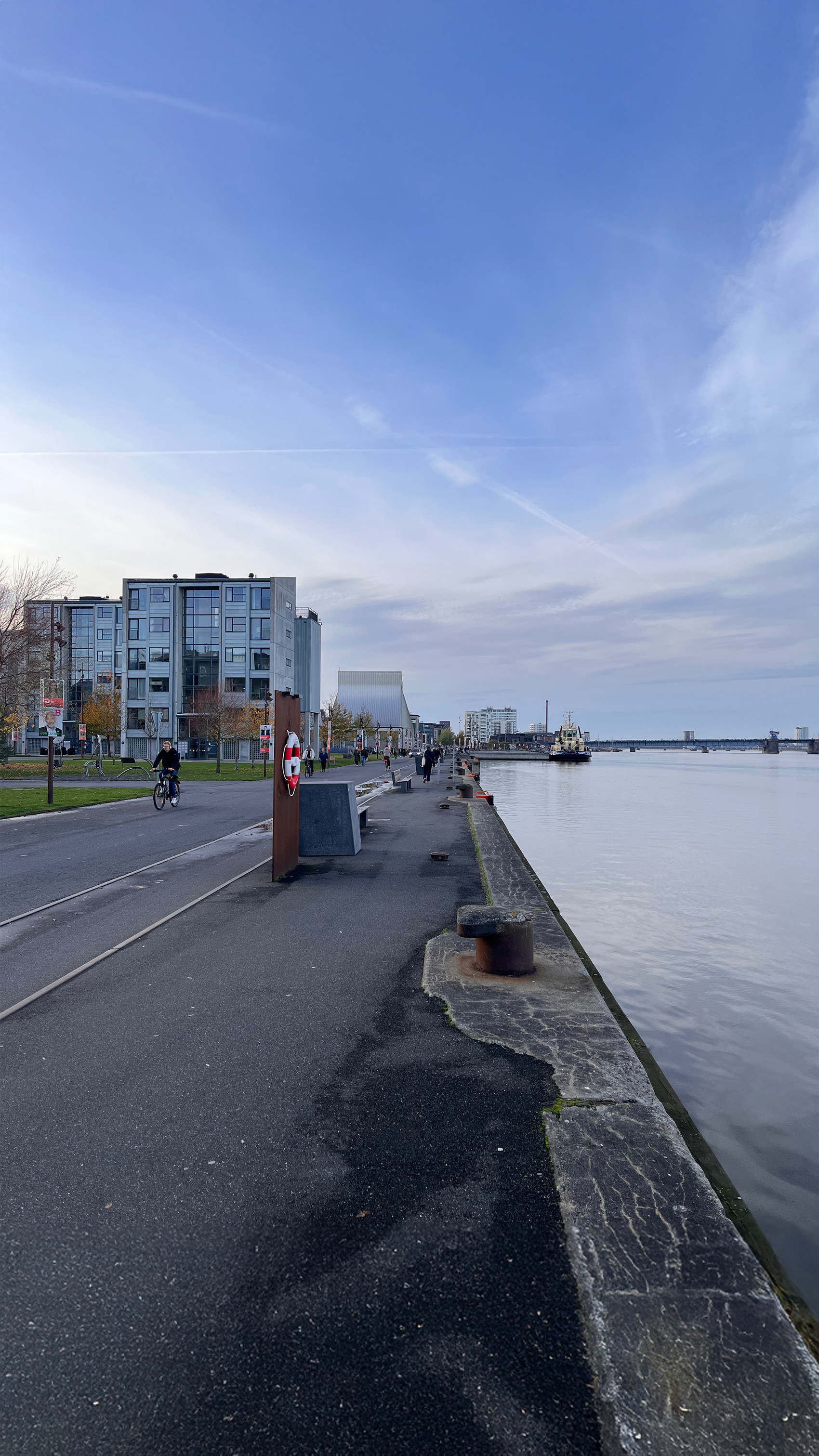  Havnesti med cyklister, moderne bygninger og roligt vand.