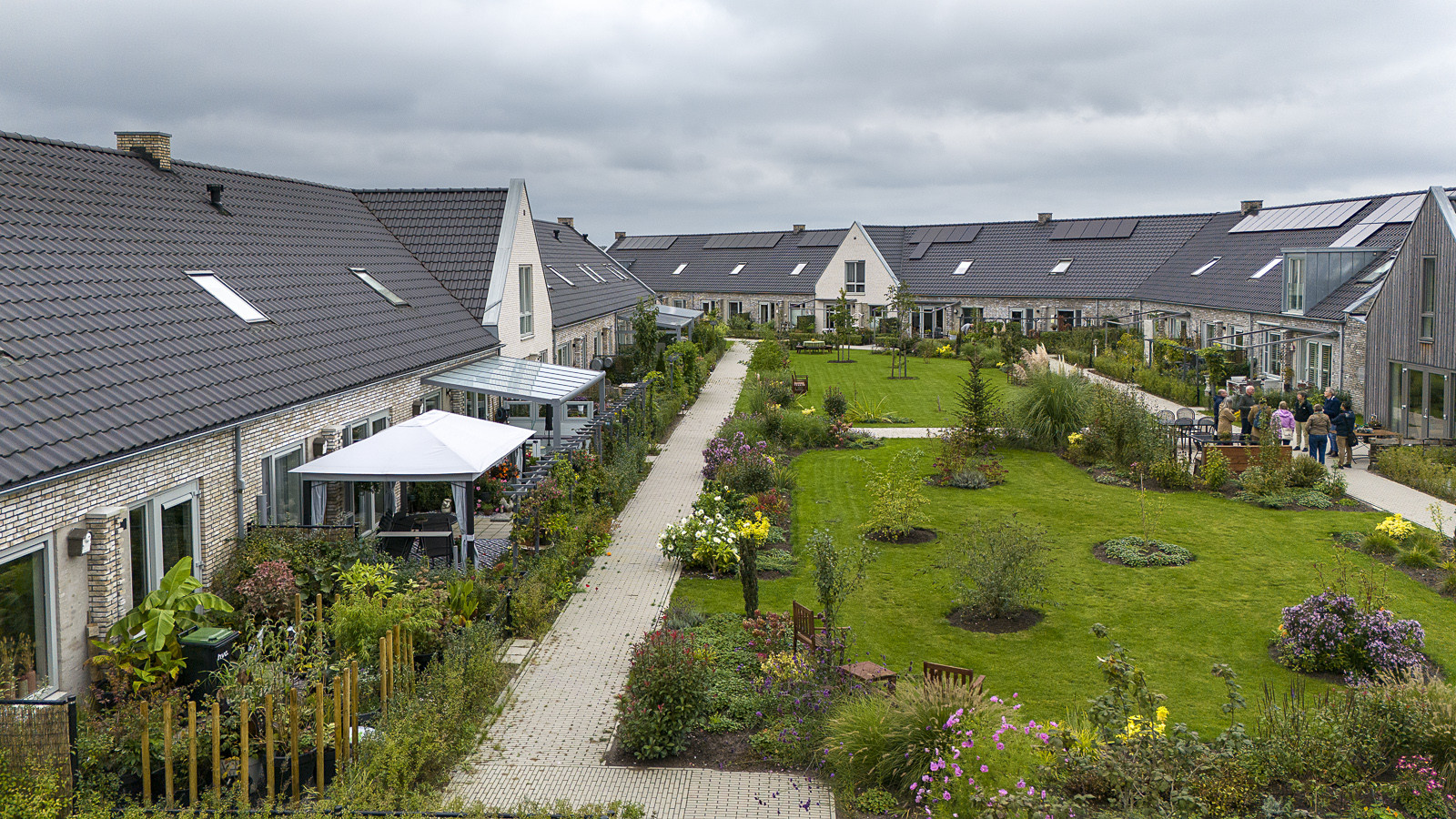 Boligområde med rækkehuse omkring fælles grøn gård med stier, beplantning og opholdsarealer