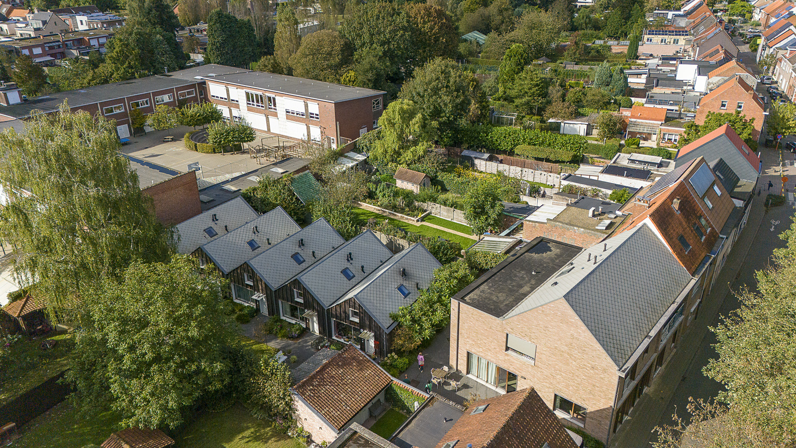 Luftfoto af boligområde med små huse, haver og fællesarealer