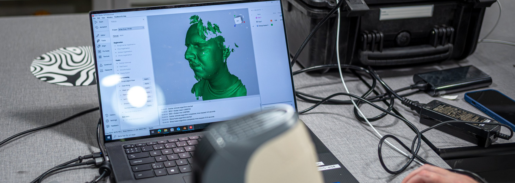 Bærbar computer viser en grøn 3D-scanning af et menneskehoved.